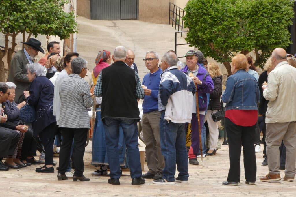 Vecinos y vecinas de Oliete compartiendo en la plaza de la Iglesia de Nuestra Señora de la Asunción.